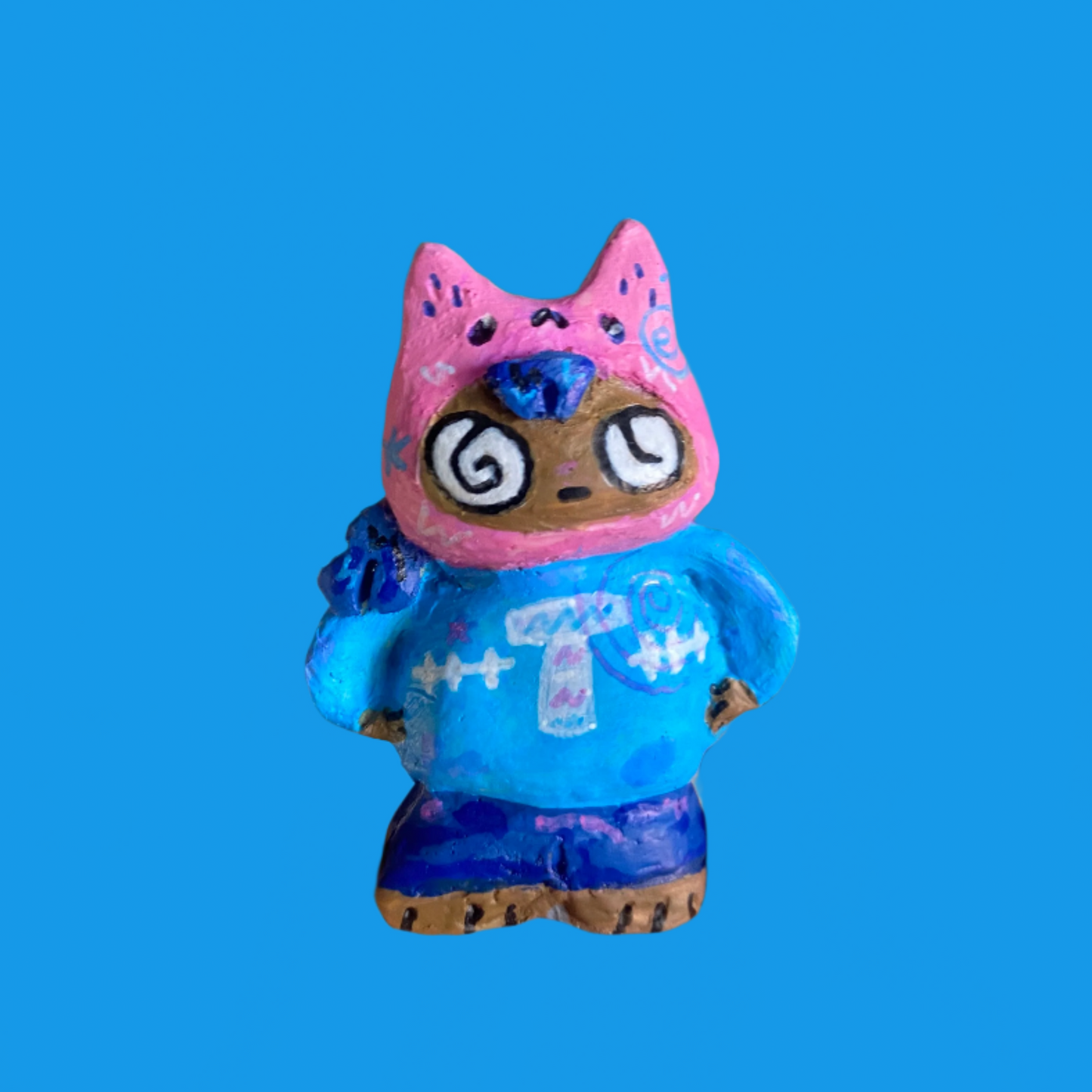 Toy figure with pink head and blue body on a blue background